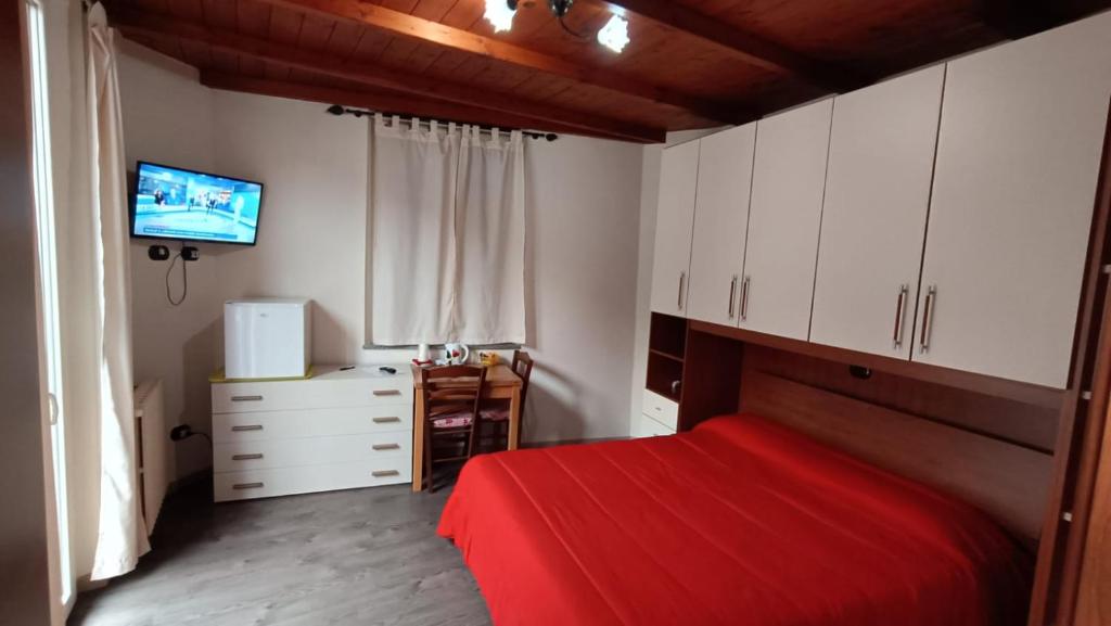 1 dormitorio con cama roja y armarios blancos en Casa Mango, en Stresa