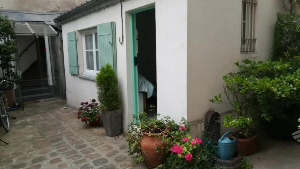 une entrée à une maison avec des plantes en pot dans l'établissement Studio cosy à Paris 12m² avec terrasse privée, à Paris