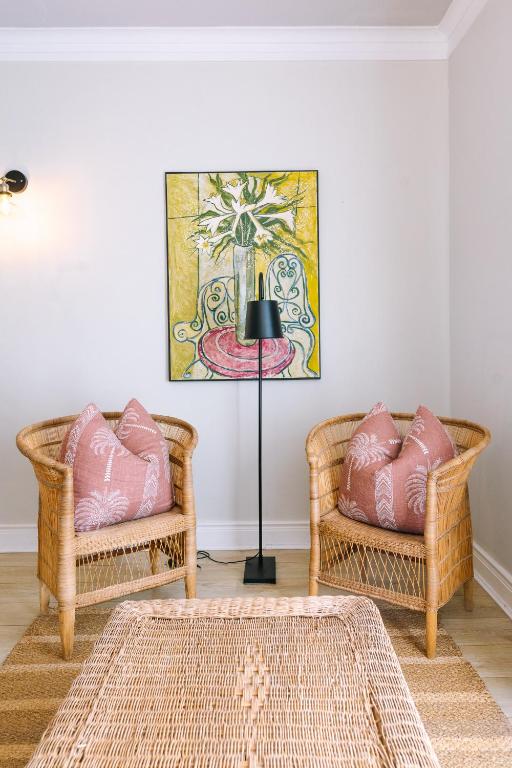 two wicker chairs and a lamp in a room at Auberge Burgundy Boutique Hotel & Spa in Hermanus