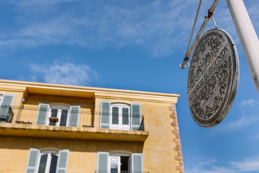 a sign hanging from a pole in front of a building at Auberge Burgundy Boutique Hotel & Spa in Hermanus