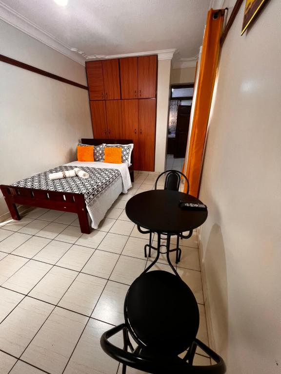 um pequeno quarto com duas cadeiras e uma cama em Studio room entebbe em Entebbe