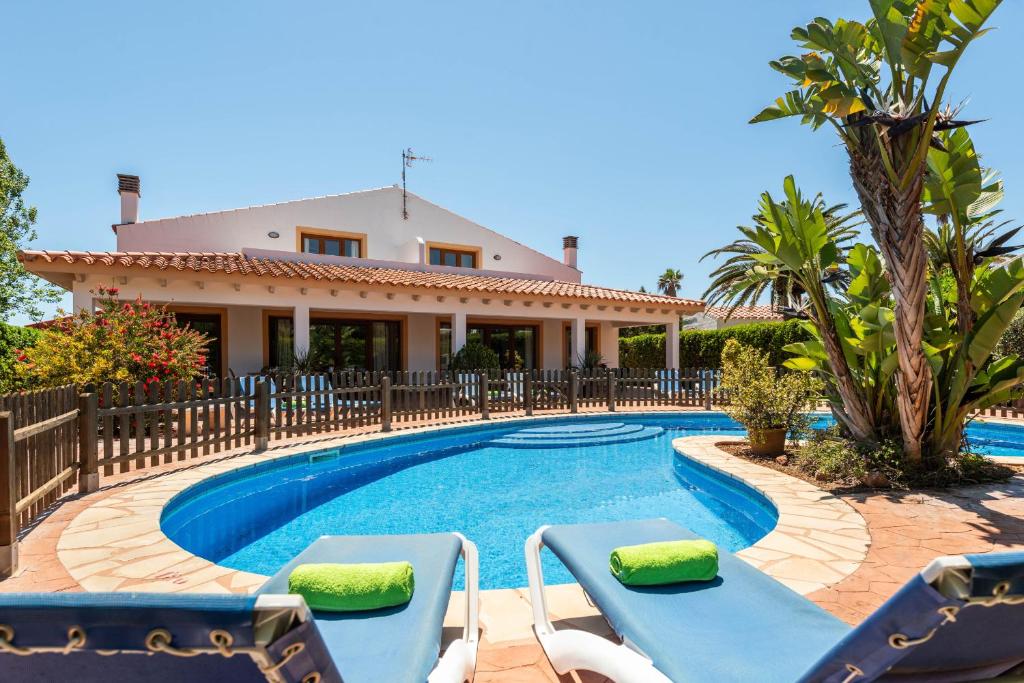 eine Villa mit einem Pool vor einem Haus in der Unterkunft Villa Angel in Son Xoriguer