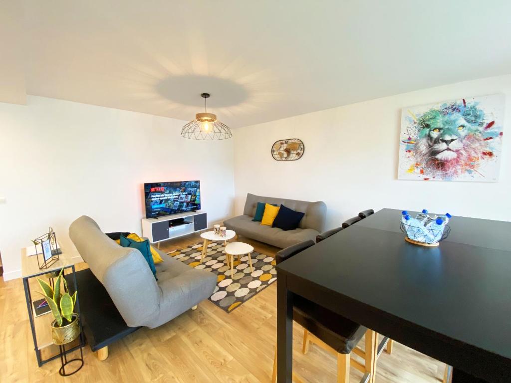 un salon avec une table et un canapé dans l'établissement Apt Val d'Europe - 10 min de Disney - Parking, à Montévrain