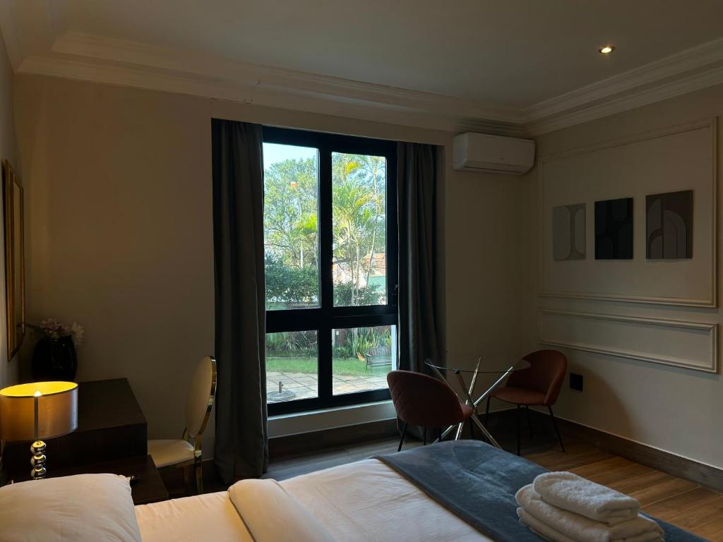 ダーバンにあるAndaluz Boutique Hotelのベッドルーム1室(ベッド1台、大きな窓付)