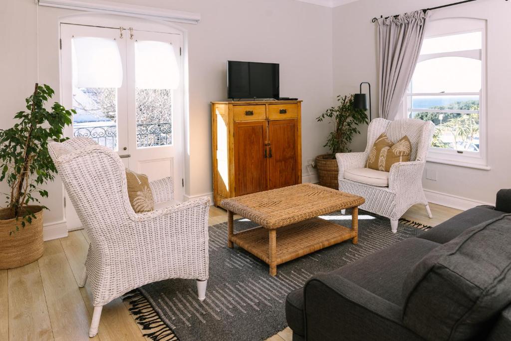 a living room with a couch and chairs and a tv at Auberge Burgundy Boutique Hotel & Spa in Hermanus