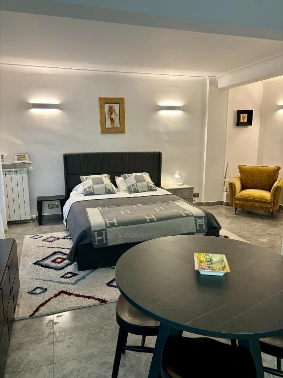 Hotel STUDIO near Monaco sea view balcony, a bedroom with a bed and a table and a chair at STUDIO near Monaco sea view balcony in Roquebrune-Cap-Martin