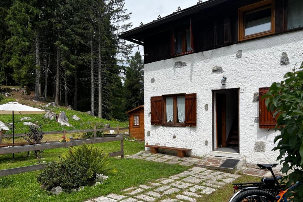 Casa ai Caprioli في بيليزانو: منزل أبيض مع دراجة متوقفة أمامه