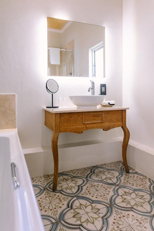 a bathroom with a sink and a mirror at Auberge Burgundy Boutique Hotel & Spa in Hermanus