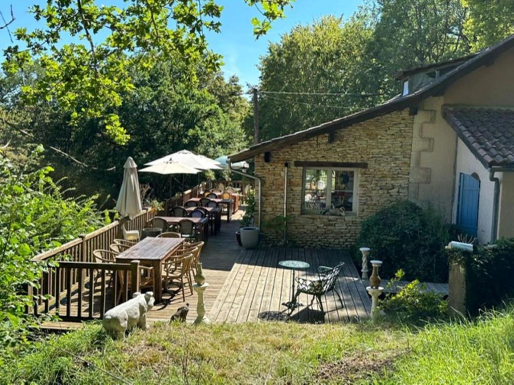 une maison avec une terrasse dotée de tables et de chaises dans l'établissement Domaine Lapin Qui Rit , chambre Céline, à Saint-Jean-de-Côle