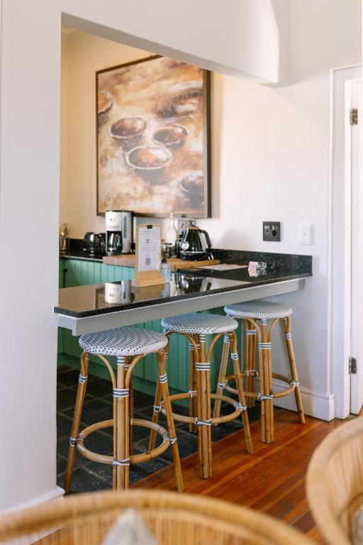 a kitchen with a counter with bar stools at Auberge Burgundy Boutique Hotel & Spa in Hermanus