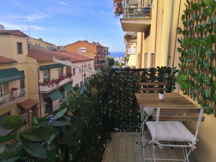 a table and chair on a balcony with plants at Lo Scorcio sul porto in Porto Santo Stefano