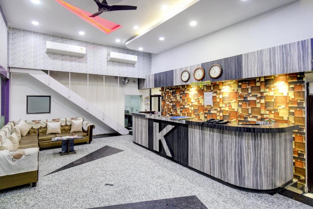 a lobby with a bar with clocks on the wall at Kyd Guest House Near Indian Museum in Kolkata