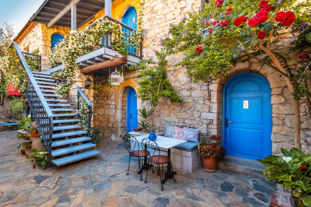 dom z niebieskimi drzwiami oraz stołem i krzesłami w obiekcie Alacati Eski Ev Hotel w mieście Alaçatı