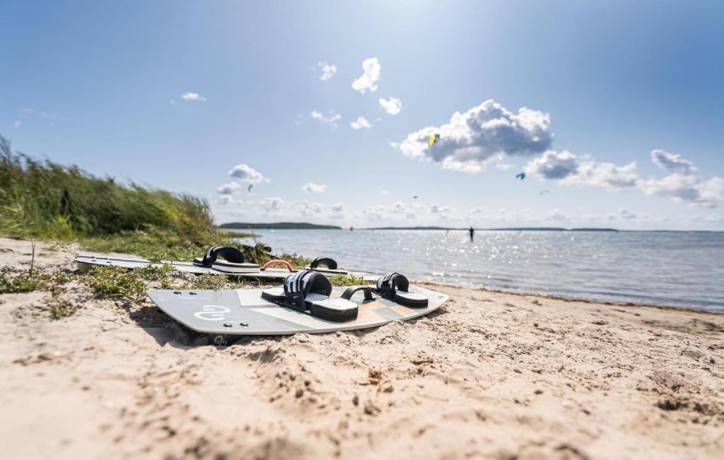 three snowboards sitting on the sand on the beach at Apartments Boddenblick in Sagard