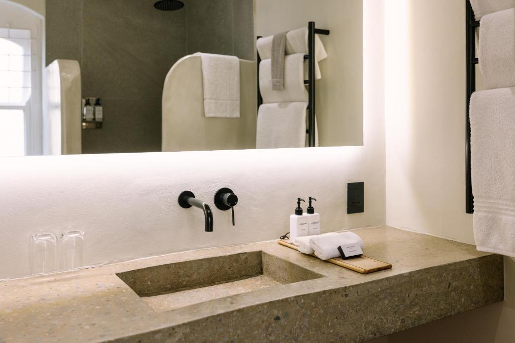 a bathroom with a sink and a mirror at Auberge Burgundy Boutique Hotel & Spa in Hermanus