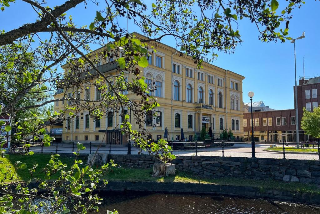 クリスティーネハムンにあるStadshotellet Kristinehamnの通りの前の大きな黄色の建物