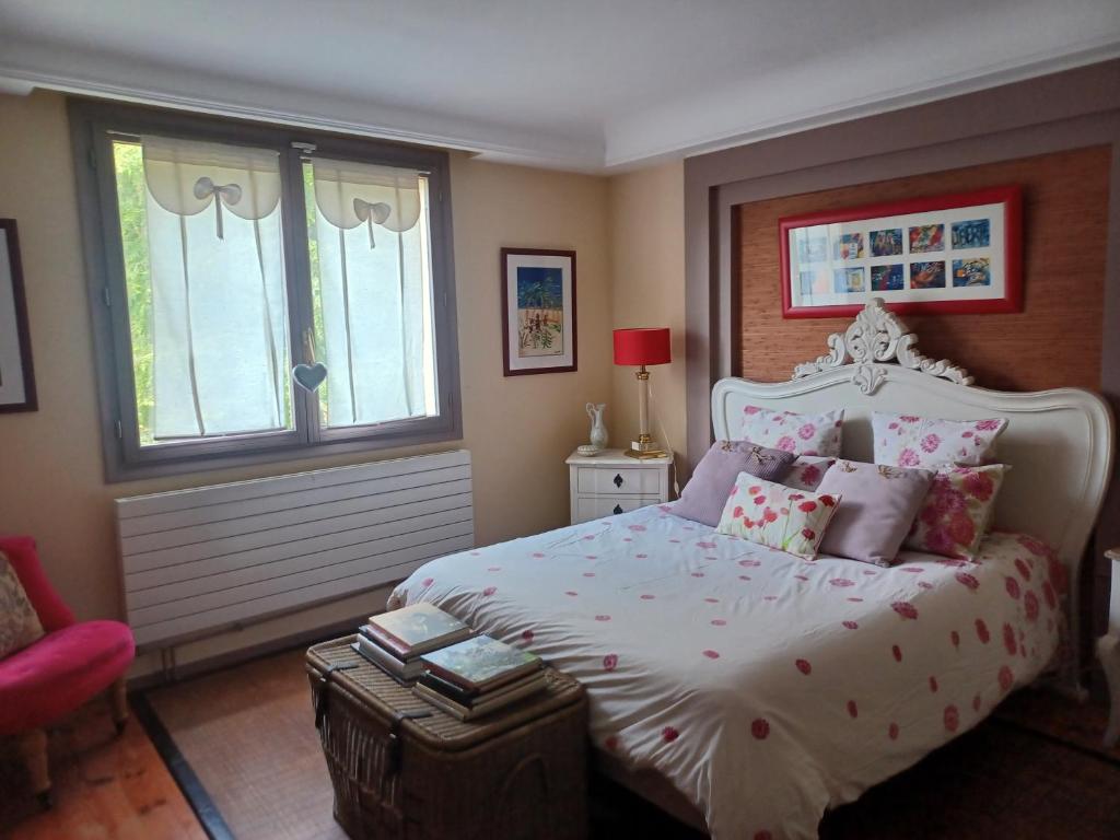 1 dormitorio con 1 cama blanca grande con almohadas rosas en Comme chez Vous, en Briis-sous-Forges
