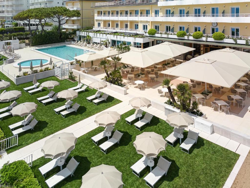 una vista aerea sul cortile di un hotel con tavoli e ombrelloni di Hotel Aurora a Lido di Jesolo