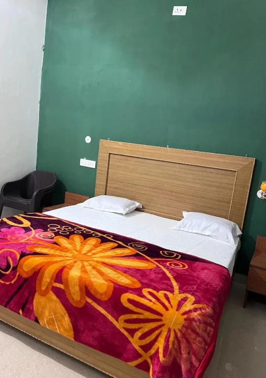 a bedroom with a bed with a flower blanket at Hotel raghunandan in Sītāpur Mūāfi