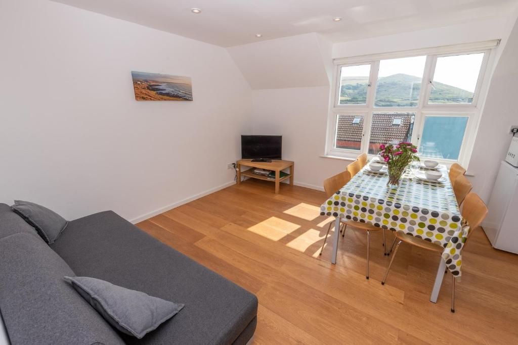 a living room with a table and a couch at Barton Road Apartment in Woolacombe