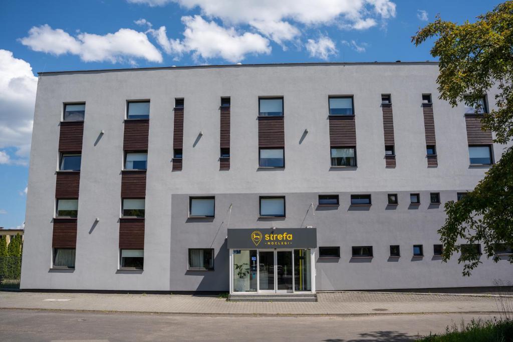 un edificio de oficinas con un cartel delante en Aparthotel Strefa Budget, en Tychy