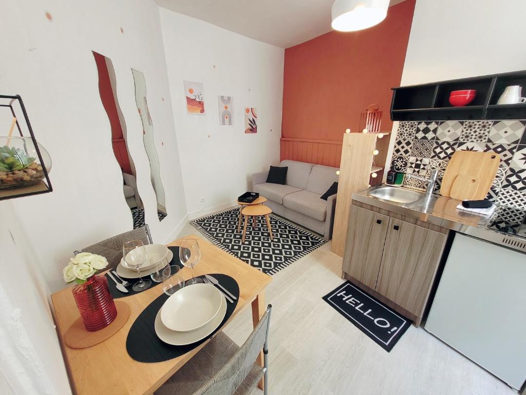 Studio hypercentre proche Vieux Marché في لا روشيل: غرفة معيشة صغيرة مع طاولة ومطبخ