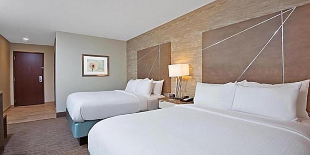 2 camas en una habitación de hotel con 2 colchas en Holiday Inn Express & Suites New Cumberland, an IHG Hotel en New Cumberland