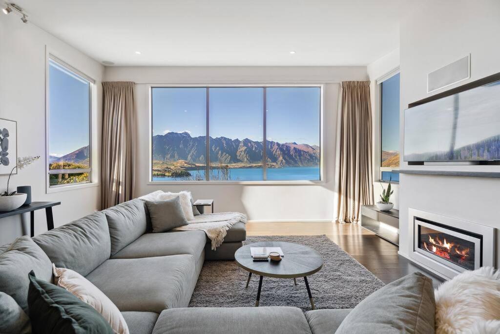 a living room with a couch and a fireplace at Luxury Retreat - Matakauri in Queenstown