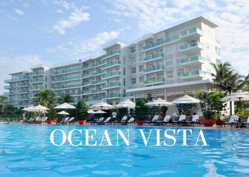 a hotel with a swimming pool in front of a building at Căn Hộ Ocean Vista 1PN in Ấp Ngọc Hải