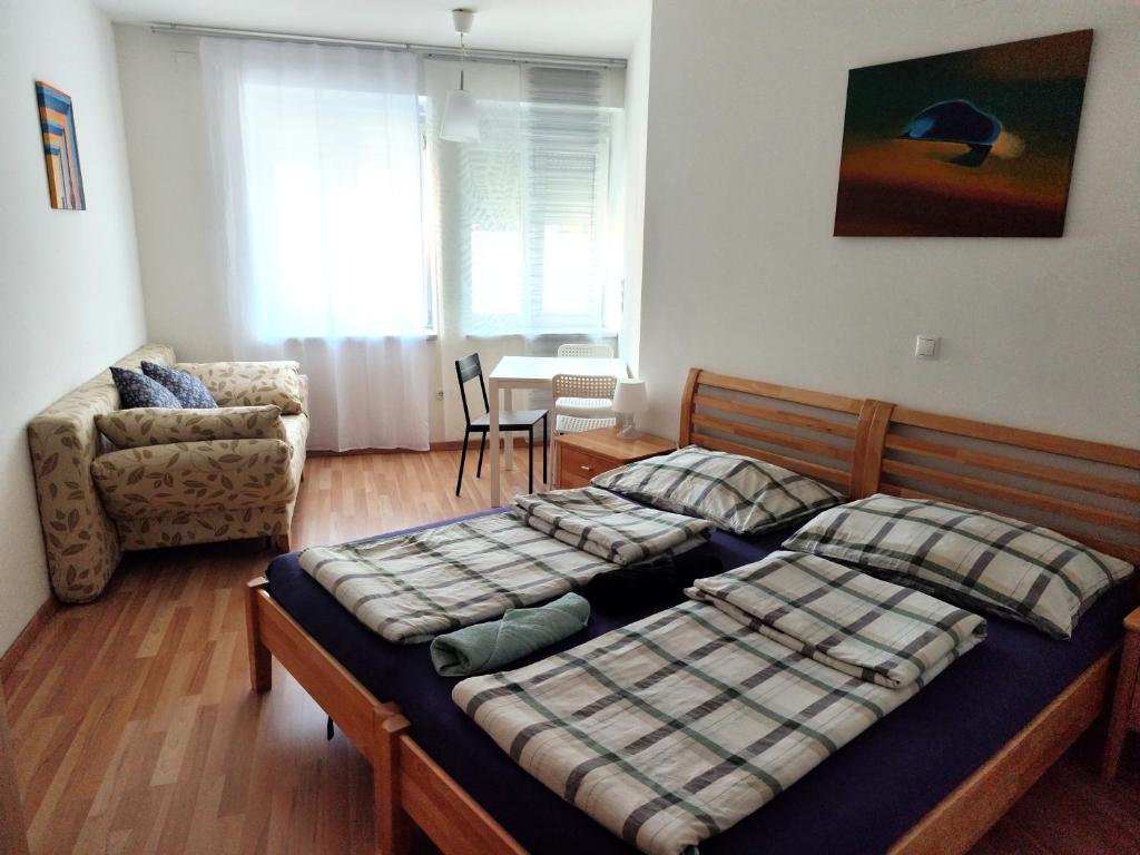 a bedroom with a bed and a couch and a chair at Hostel&ApartServices Vienna in Vienna
