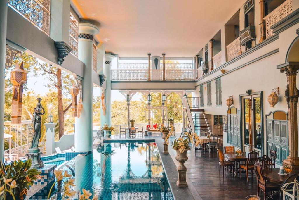an indoor pool in a house with tables and chairs at At Pingnakorn Huaykaew in Chiang Mai