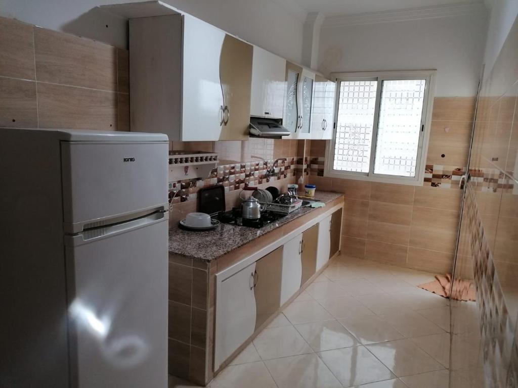 a kitchen with a white refrigerator and a counter at Jamila appart pr famille couples non in Meknès
