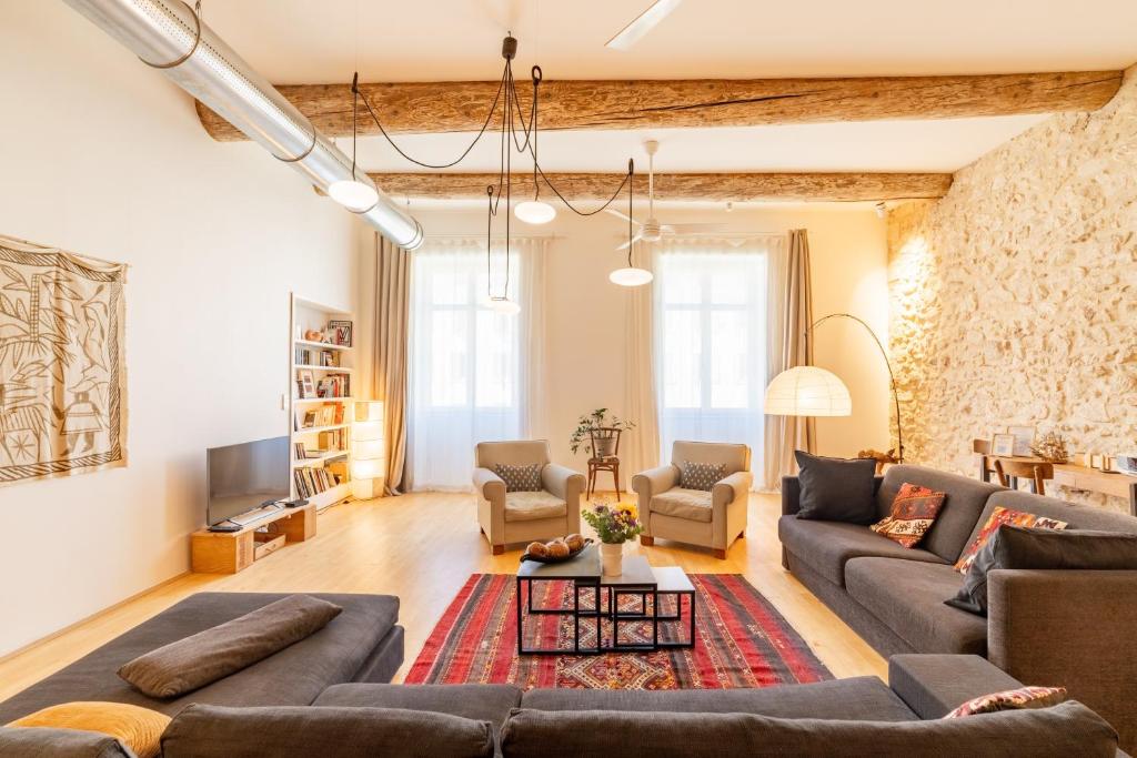 - un salon avec des canapés et une télévision dans l'établissement L'Arsenal - très bel appartement sur le Vieux-Port, à Marseille