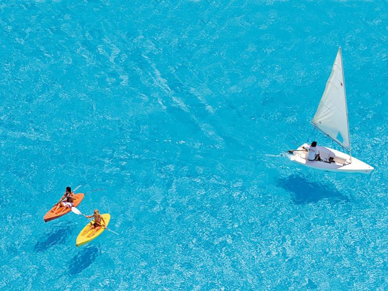 dos personas en tablas de surf y un velero en el agua en Vive San Alfonso del Mar, en Algarrobo