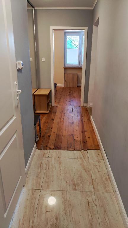 an empty room with a door and a wooden floor at Apartament Nowogard Centrum - Self Check in - Wejście na KOD in Nowogard