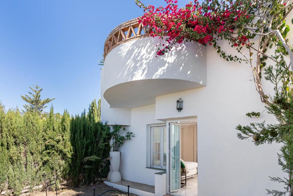 une maison blanche avec un panier de fleurs sur son côté dans l'établissement MONKÓ VILLA CASABLANCA, à Benalmádena