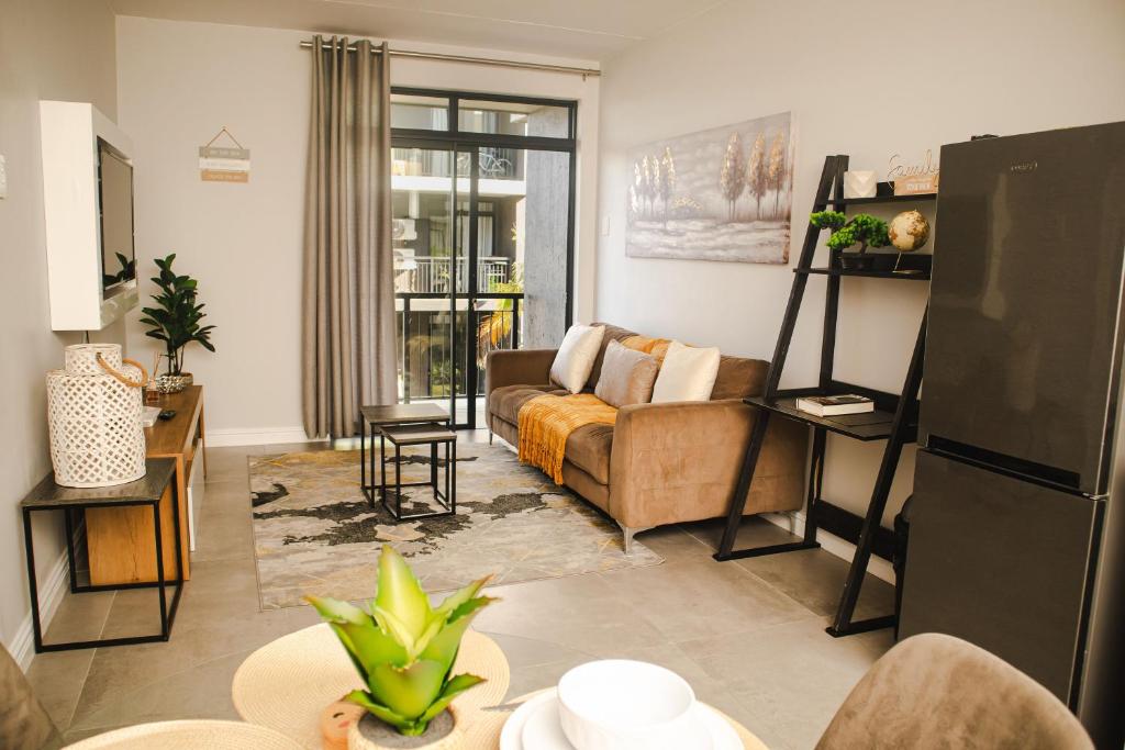uma sala de estar com um sofá e uma mesa em Modern 2 Bedroom 2 Bathroom Apartment Incl Gym em Ballito