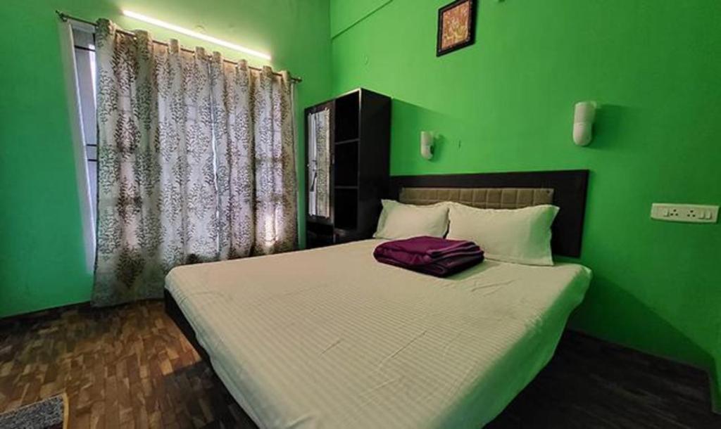 um quarto verde com uma cama com um saco roxo em FabExpress MK Homes em Kodaikanal