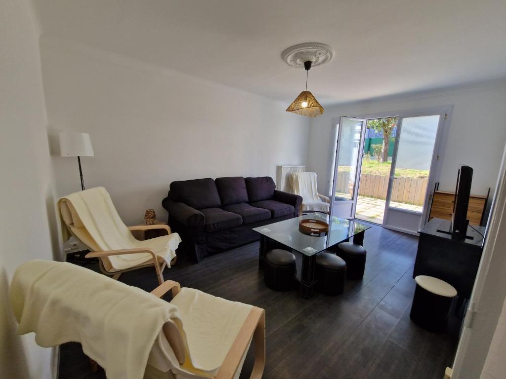 a living room with a couch and a table at Maison 6 chambres Saint Nazaire 5 min de la mer in Saint-Nazaire