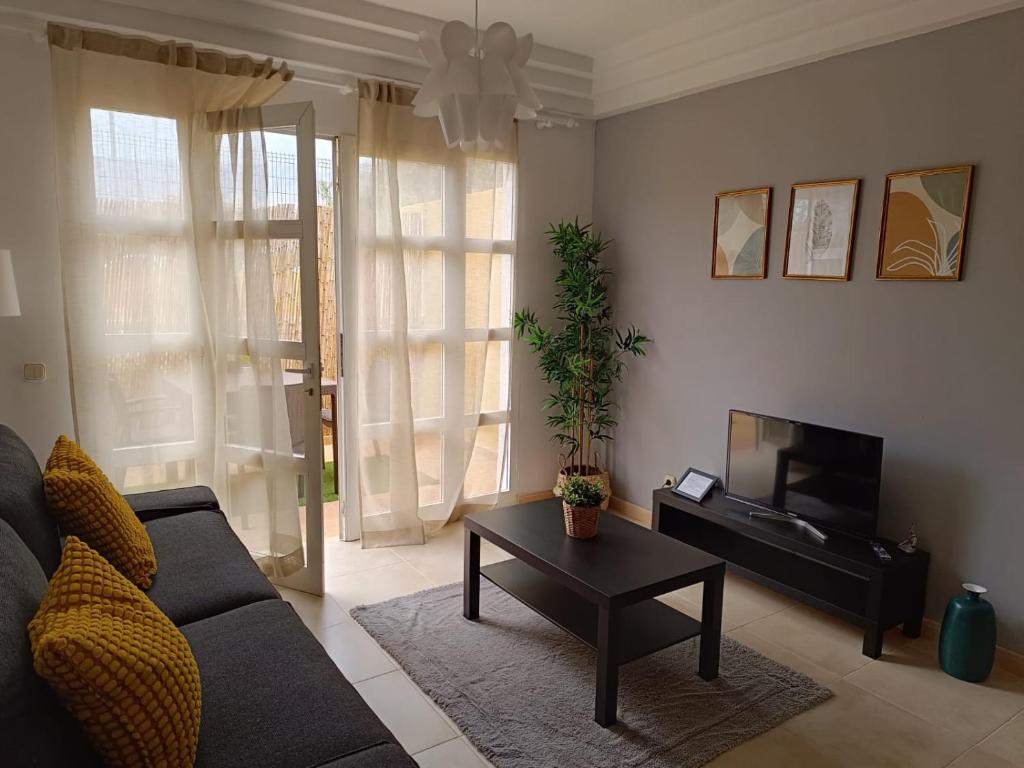 a living room with a couch and a table at Apartamentos ORLANDO en Costa Adeje in Adeje