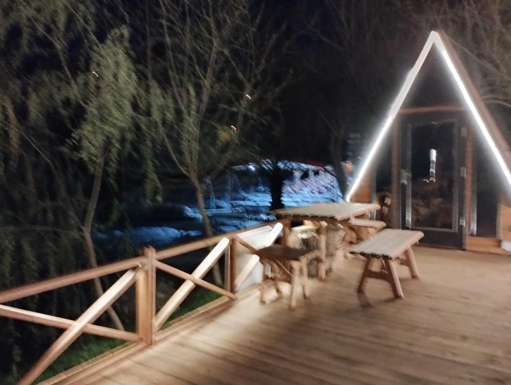 a wooden deck with benches and a house at night at Fio's Garden camping otel in Aksaray
