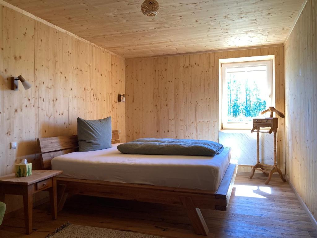 1 dormitorio con 1 cama en una pared de madera en Ferienwohnungen im Teichland Linum, en Linum