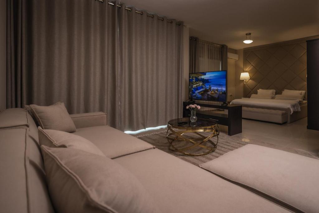a living room with a couch and a tv at Ankars Suites & Hotel in Ramallah
