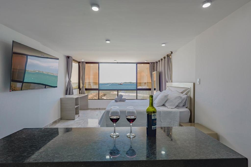 two wine glasses sitting on a table in a room at Lujoso apartamento con vista al mar in Cartagena de Indias