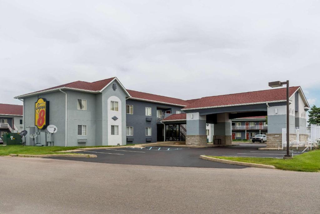 a hotel front of a building with a parking lot at Super 8 by Wyndham Indianapolis/NE/Castleton Area in Indianapolis