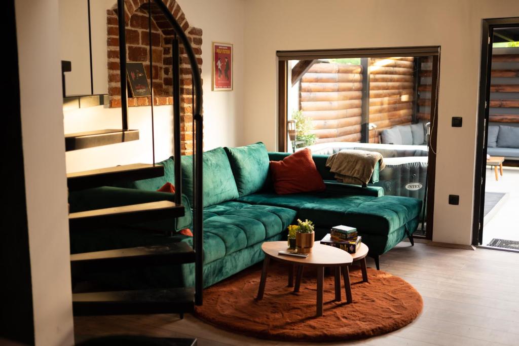 uma sala de estar com um sofá verde e uma mesa em Golden Pinpoint em Gornje Vratno