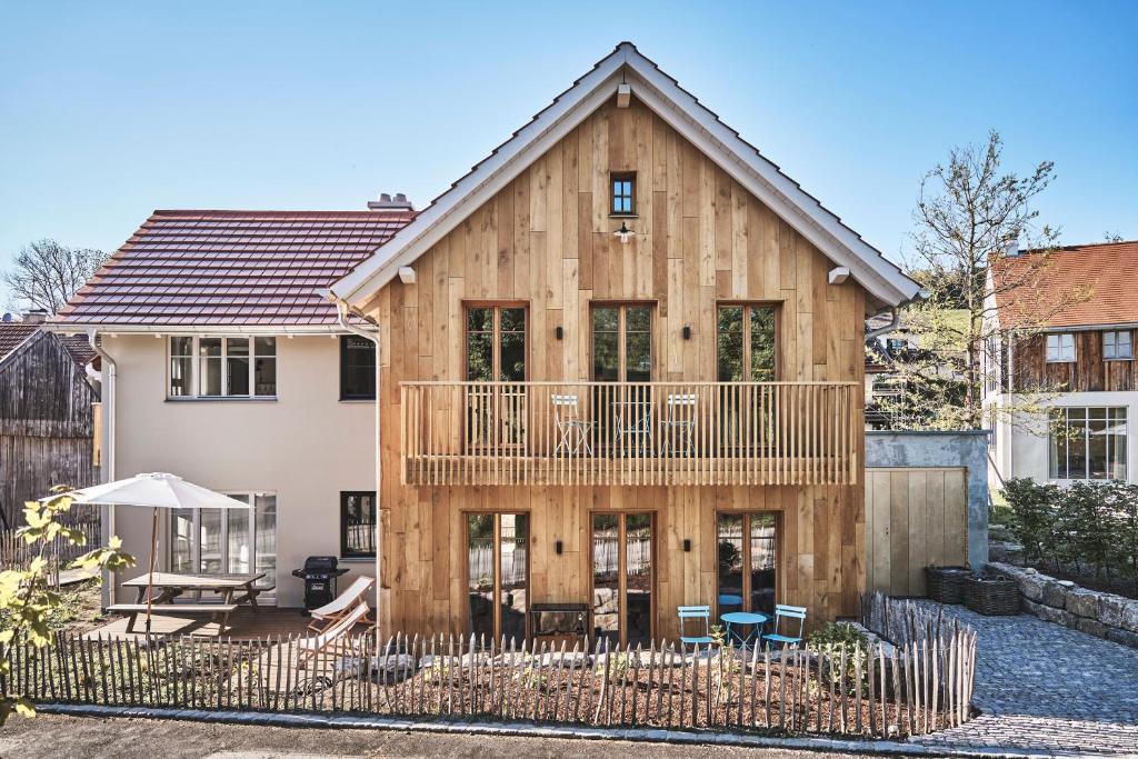 een houten huis met een terras en patio bij Das Flachshaus Boutique Apartments 