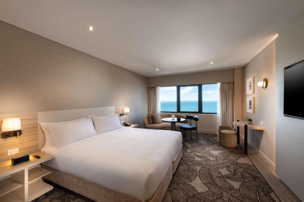 um quarto de hotel com uma cama grande e uma televisão em Hilton Darwin em Darwin