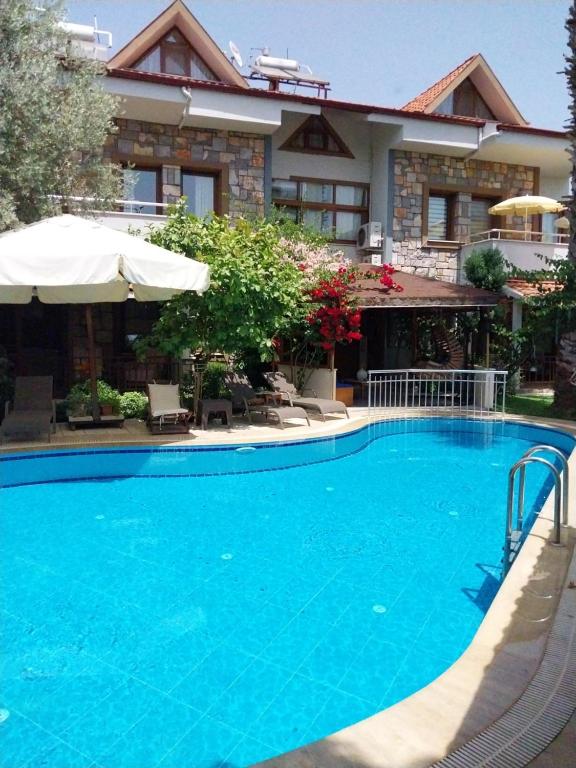 a large blue swimming pool in front of a building at Jasmin Apart Otel in Göcek