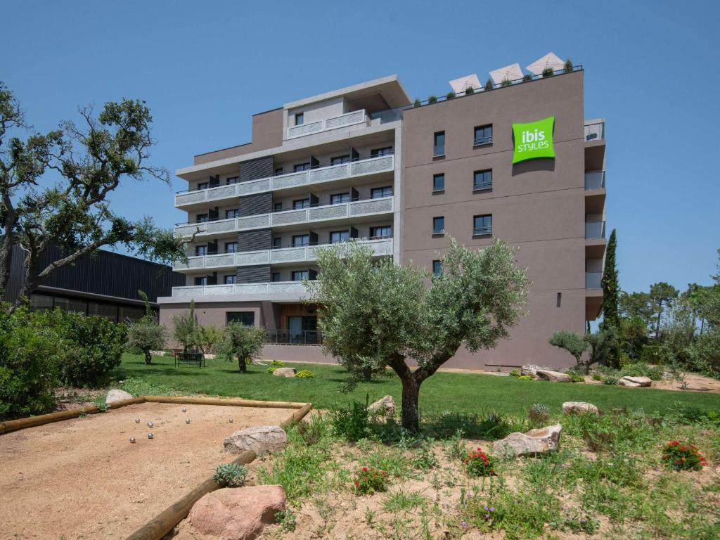 a large building with a tree in front of it at ibis Styles Porto Vecchio in Porto-Vecchio